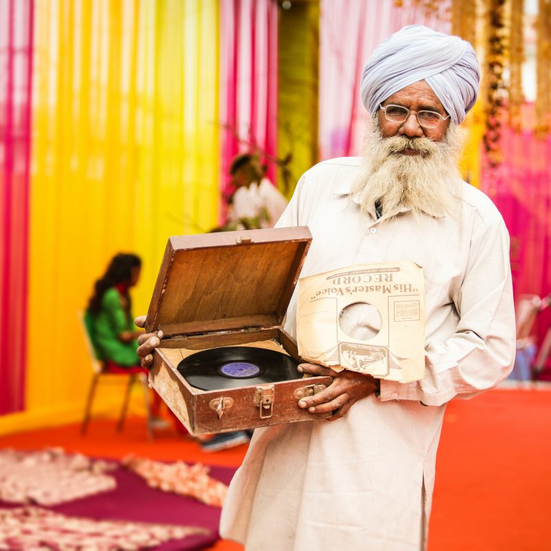 Man in turban holding record player