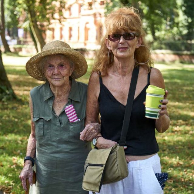 Older woman walking arm in arm with younger woman