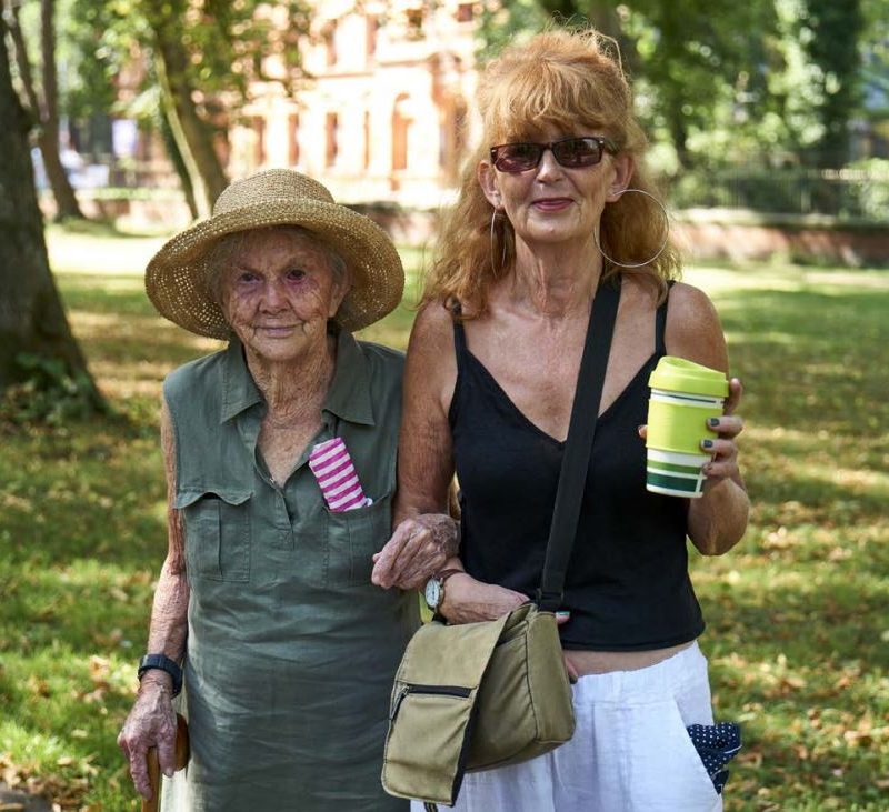 Older woman walking arm in arm with younger woman