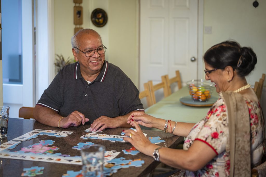 Older man and woman enjoying doing puzzle together