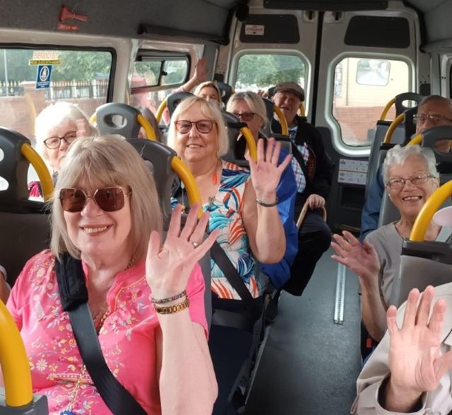 Older people waving on a bus