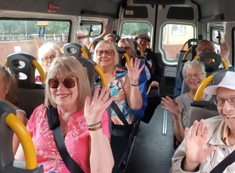 Older people waving on a bus