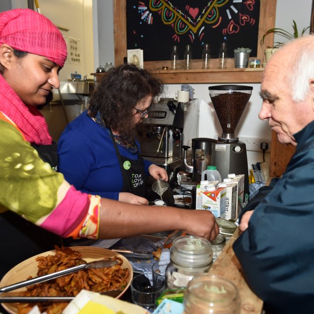 Woman serving older man in a cafe