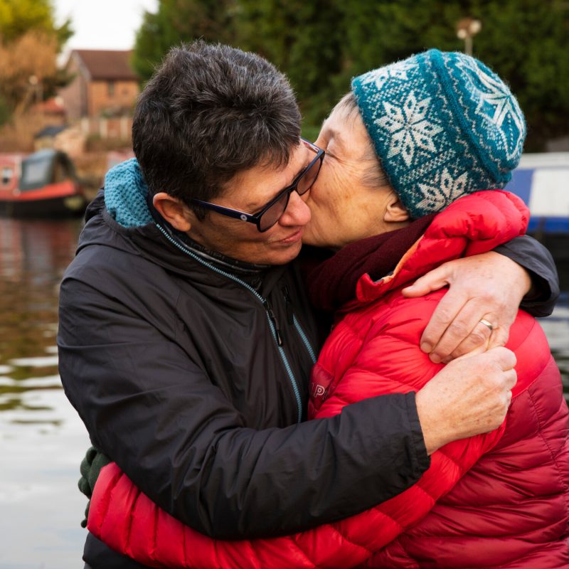 Older couple embracing next to a canal