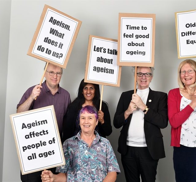 5 people each holding a placard, which say: "Let's talk about ageism", "Ageism. What does it do to us?", "Time to feel good about ageing", "Older. Different. Equal.", "Ageism affects people of all ages."