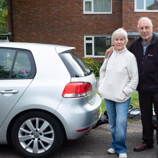 Older couple standing next to a car