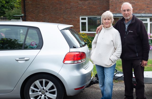 Older couple standing next to a car