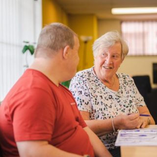 Older woman sat talking with younger man